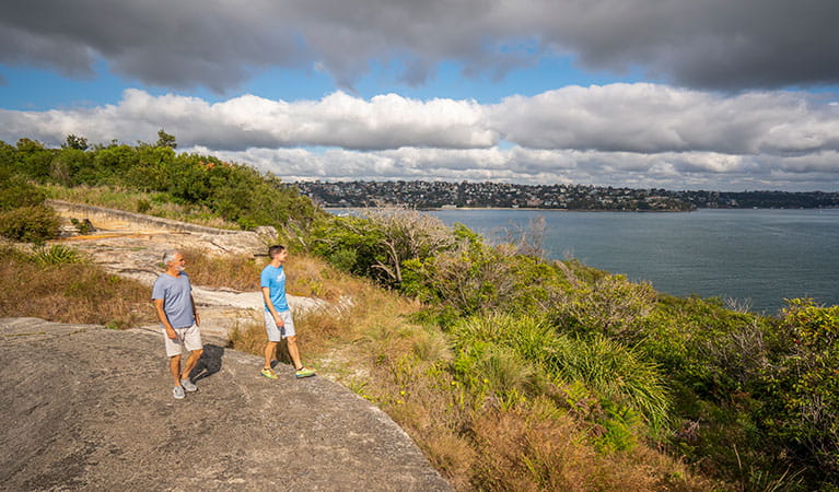 Two people looking out over the harbour at Middle Head forts in Sydney Harbour National Park. Photo: John Spencer/DPIE